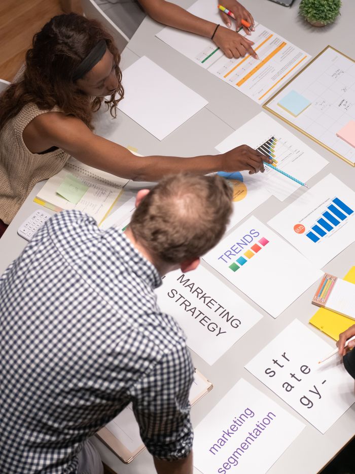 Team discussing marketing strategies in a modern office setting with charts and documents.
